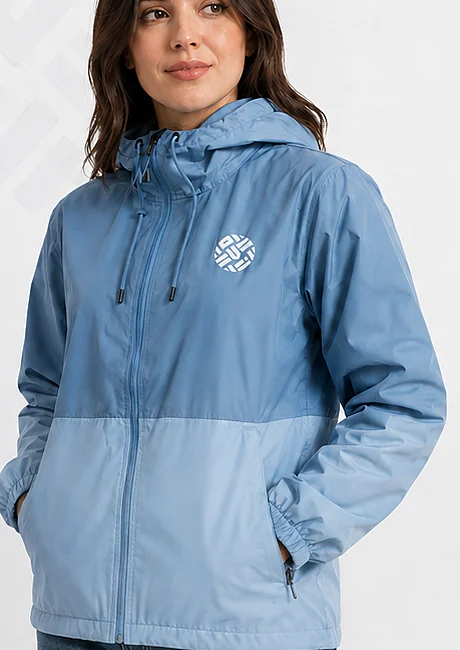 Modelo con chaqueta azul bicolor con logotipo bordado